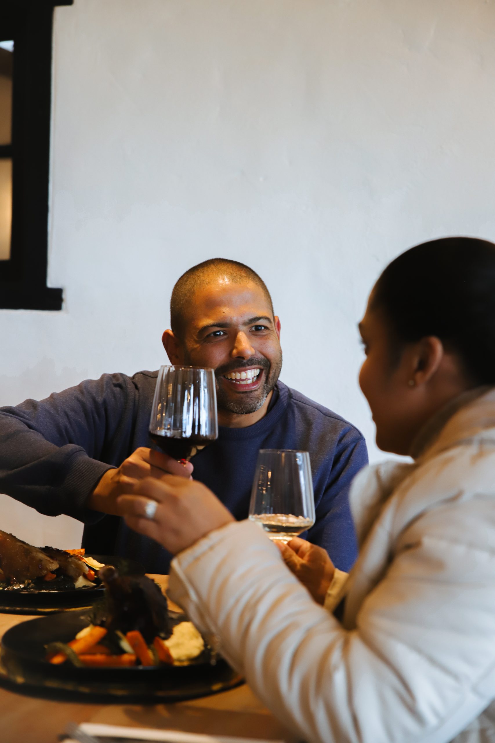 Couple toasting with wine over dinner