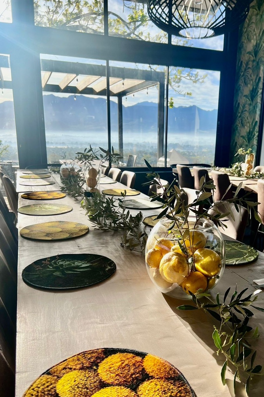 Long dining table set with lemons and olive branches